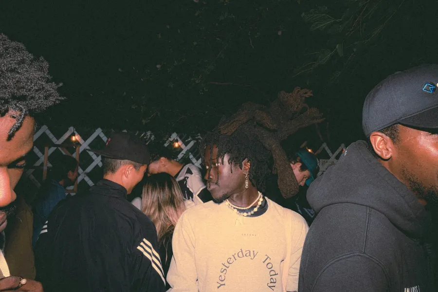 People close together at a gathering, photographed in the warm light of the evening.